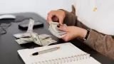 Persona contando dólares