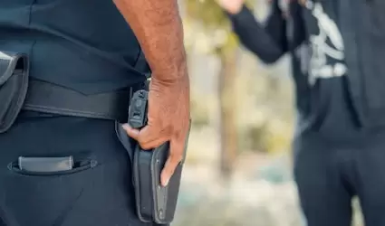 Polica arrestando a joven al aire libre