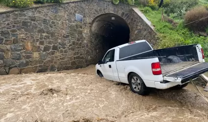 Rescatan a persona de su vehculo atascado en arroyo de Rosarito