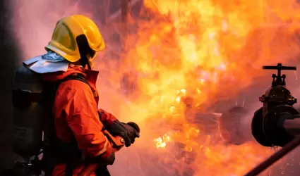 Bombero utiliza extintor de incendios de tipo niebla de agua para combatir con l