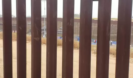 Migrantes en el muro fronterizo