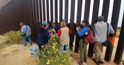 Migrantes en el muro fronterizo