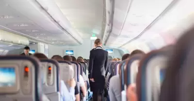 Azafata. Interior del avin con pasajeros en asiento durante el vuelo.