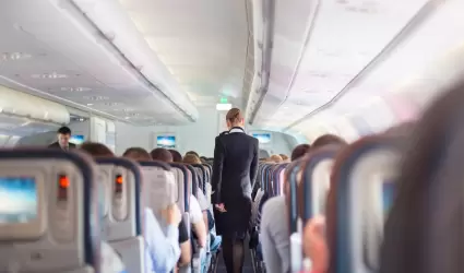 Azafata. Interior del avin con pasajeros en asiento durante el vuelo.