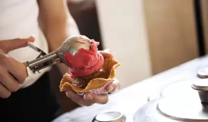 Joven sirviendo helado en cono