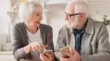 Pareja de ancianos y abuelos esposos que usan teléfonos celulares inteligentes j
