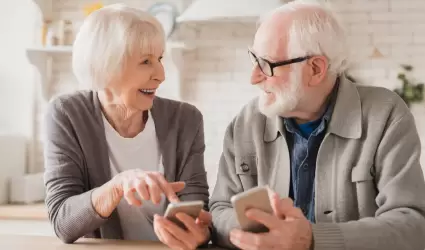 Pareja de ancianos y abuelos esposos que usan telfonos celulares inteligentes j