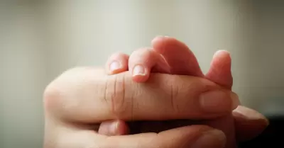 Madre sosteniendo la mano de su hija