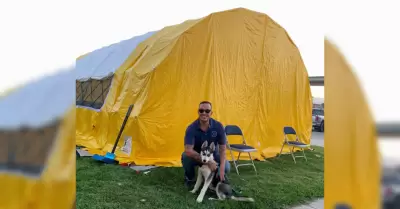 El Supervisor de cuidado animal, Manny Salazar, posa con un husky evacuado