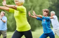 Personas mayores locales se frotan las rodillas practicando Tai Chi