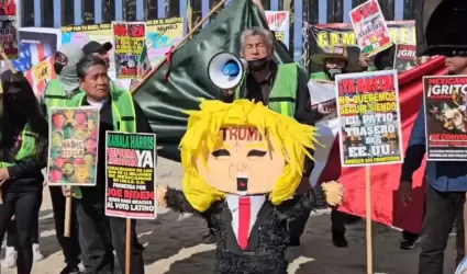 Activistas queman piata con la figura de Trump frente al muro internacional en 