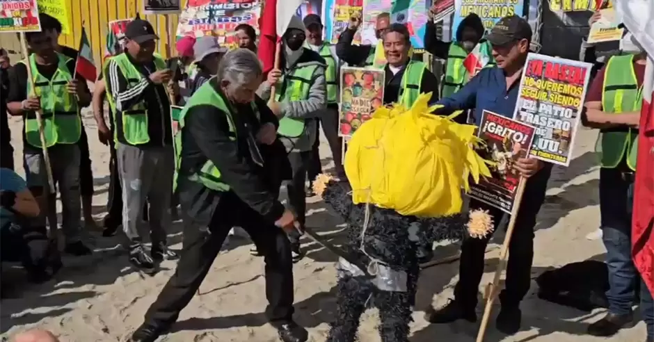 Activistas queman piata con la figura de Trump frente al muro internacional en Playas de Tijuana